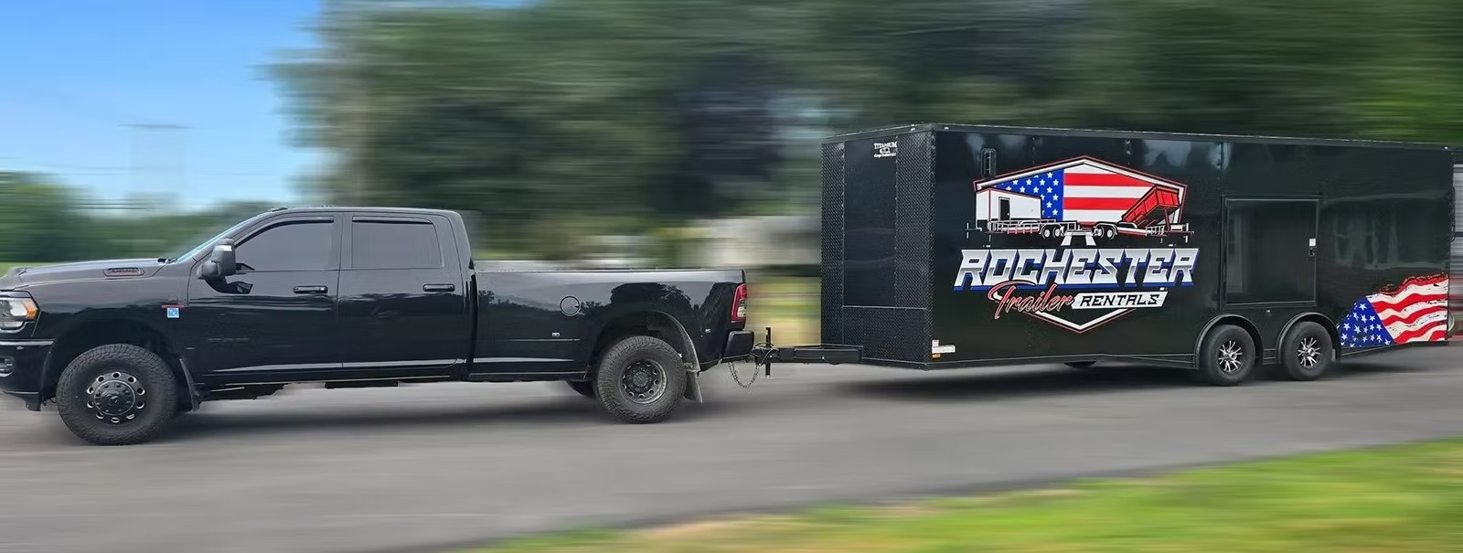 Truck towing a Rochester Trailer Rentals enclosed trailer down the highway
